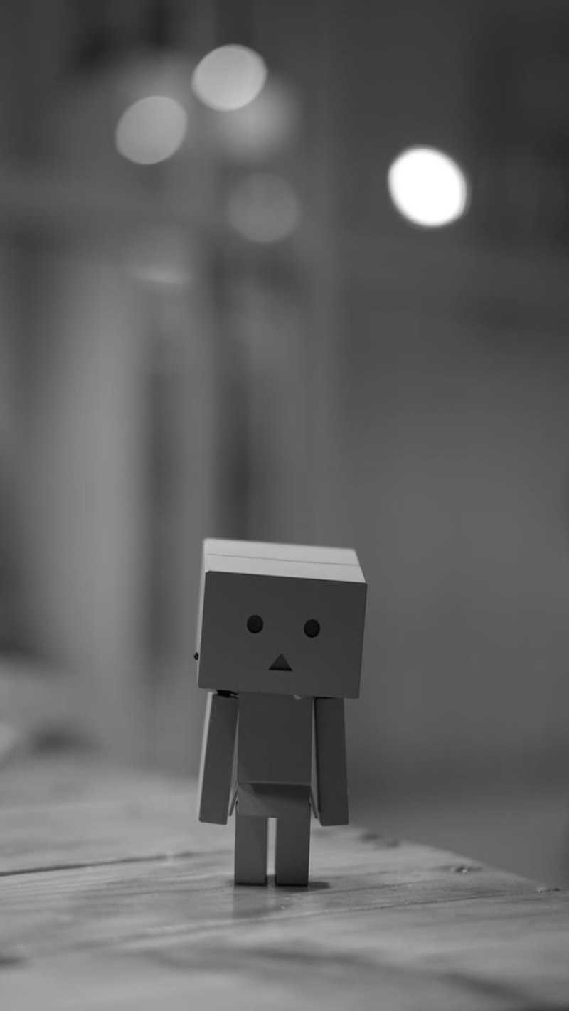 A sad robot toy in black and white.